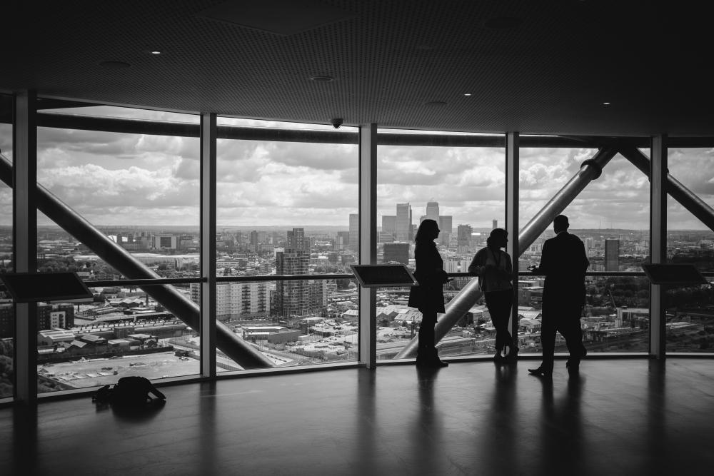Business professionals in suits shaking hands in an office, symbolizing deal origination and mergers and acquisitions (M&A) advisory